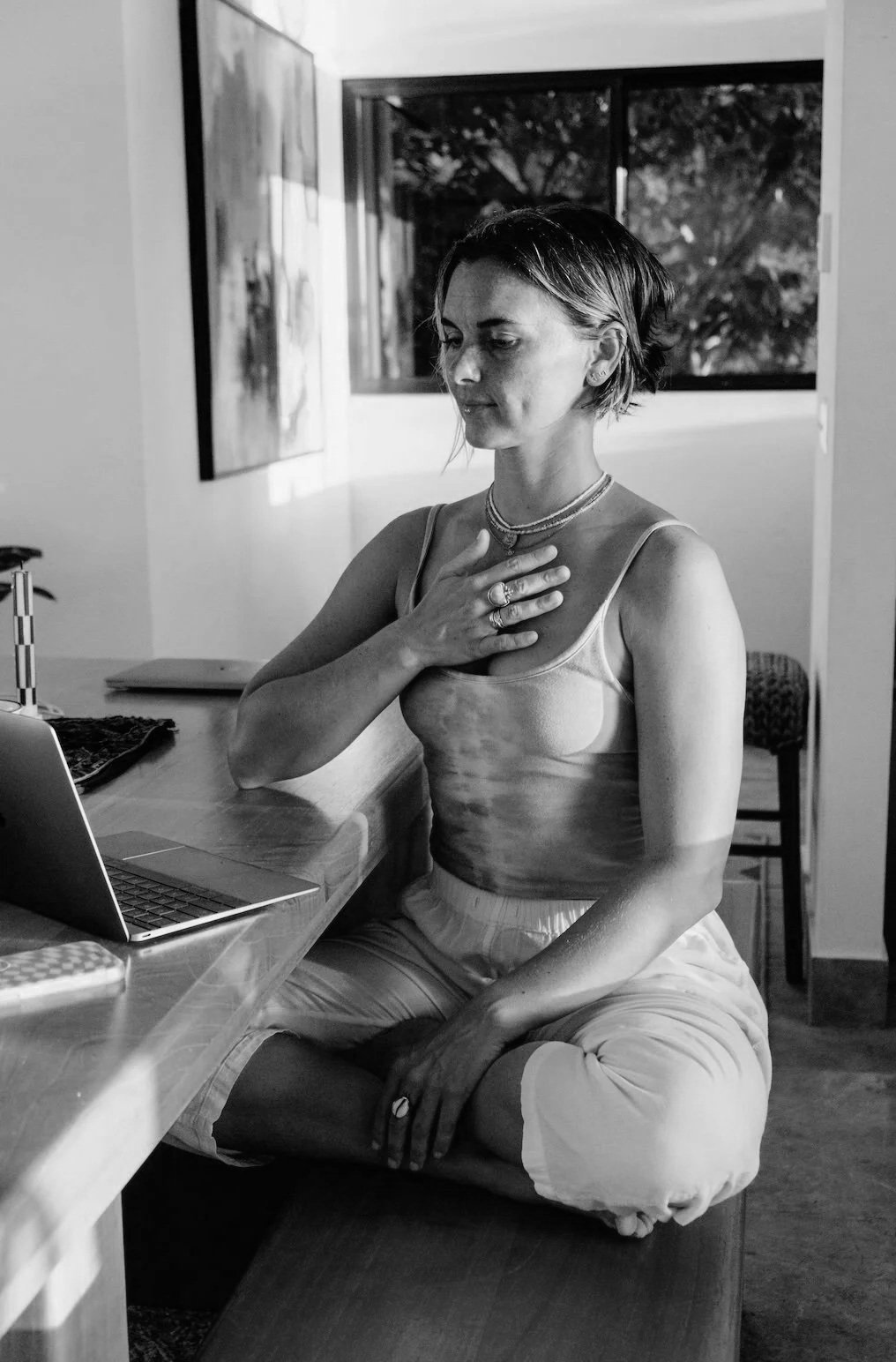 A member in an online session, one hand resting on her chest